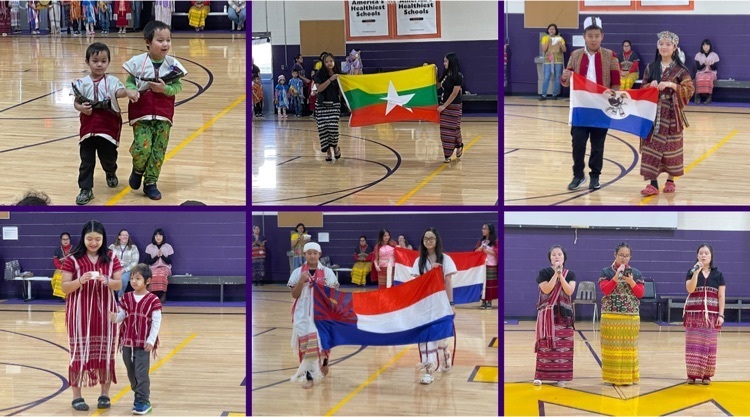 students walking through the gym displaying their native flags 