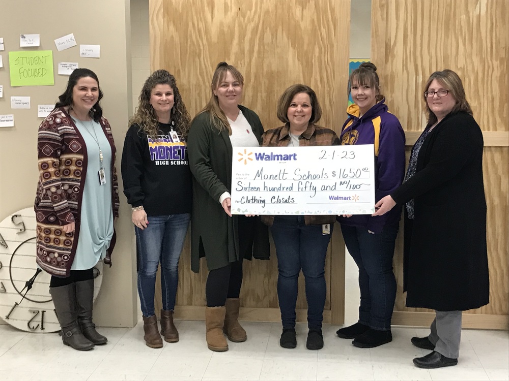 District counselors hold $1650 grant check from Walmart for Care to Learn