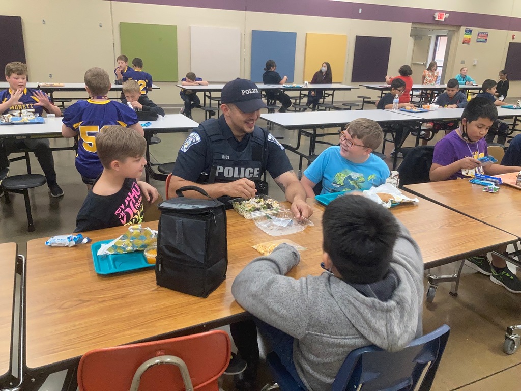 Officer Rice eats lunch with students. 