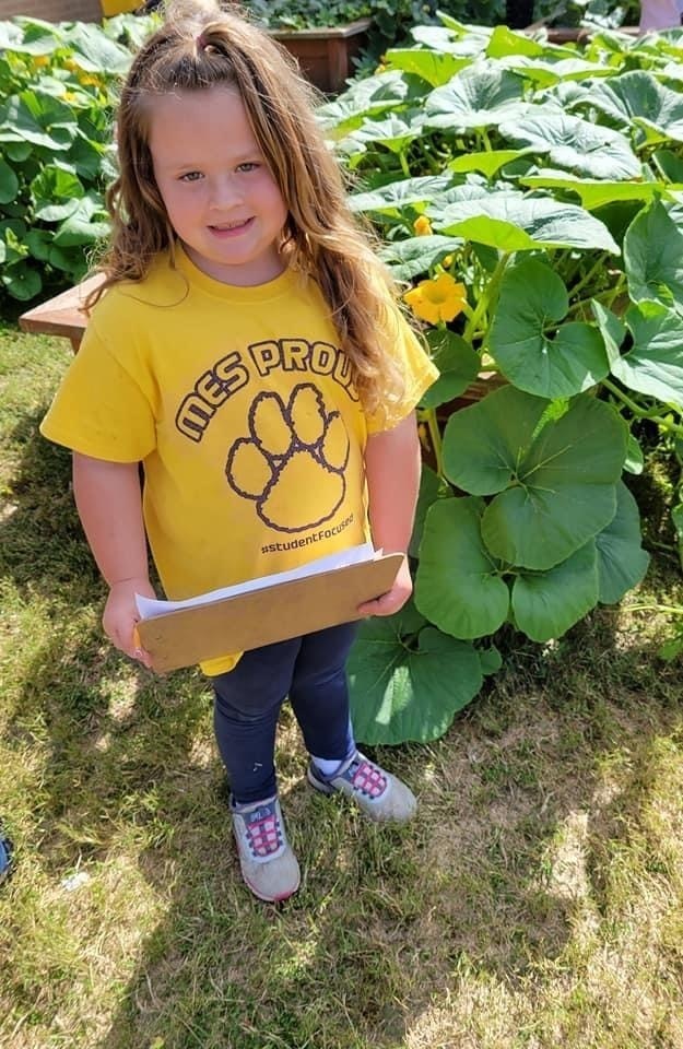 Student stops to take a quick photo from observing pumpkins. 