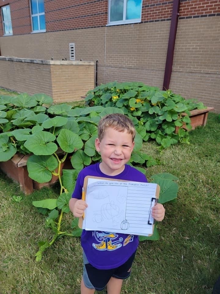 Student stops to take a quick photo from observing pumpkins. 