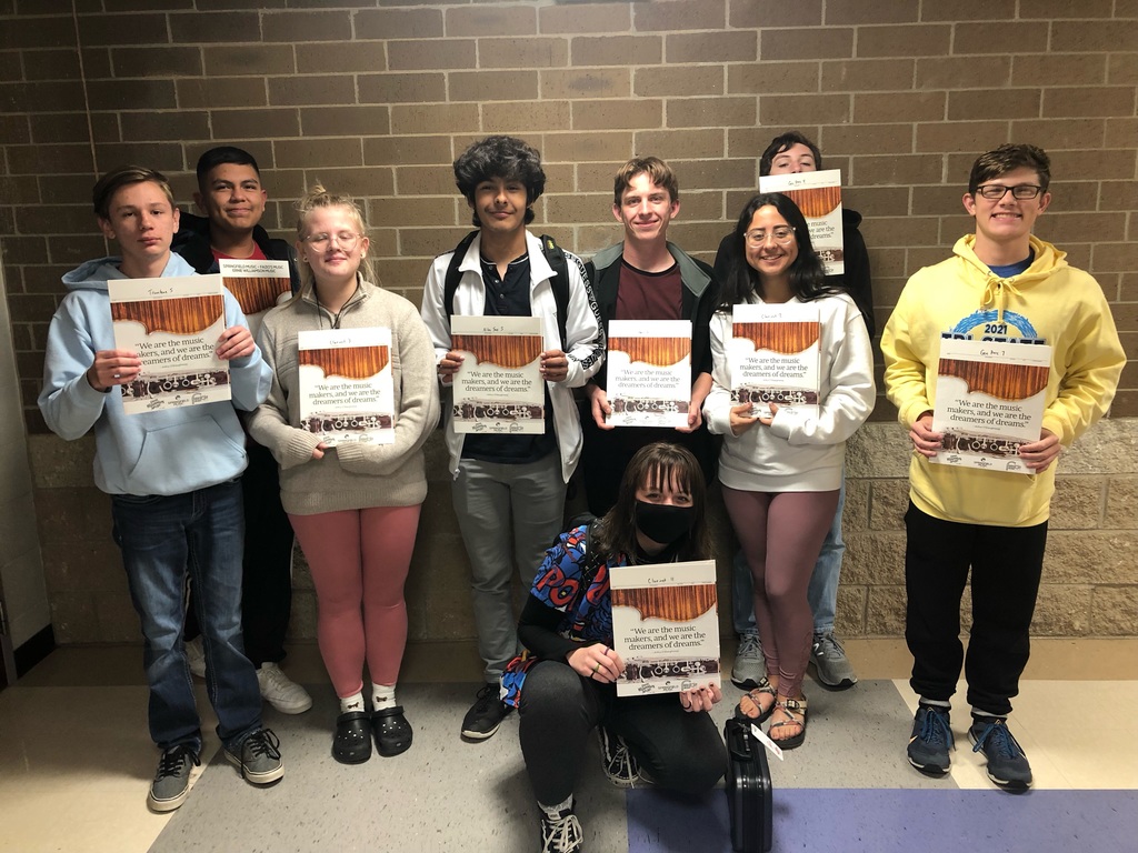 Band Students holding up their band books. 