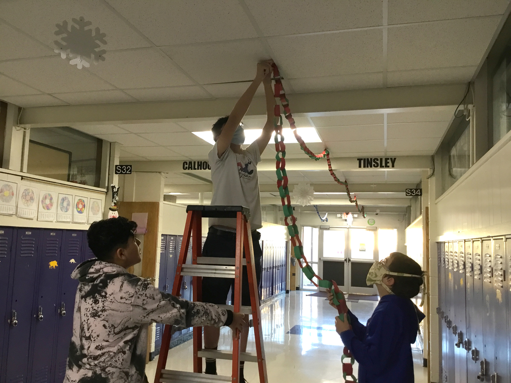 Students hanging paper chain links in the hallway. 
