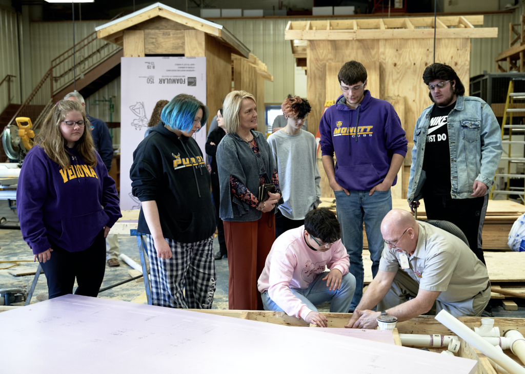 Margie Vandeven talks to students while they work on their construction project in construction class. 