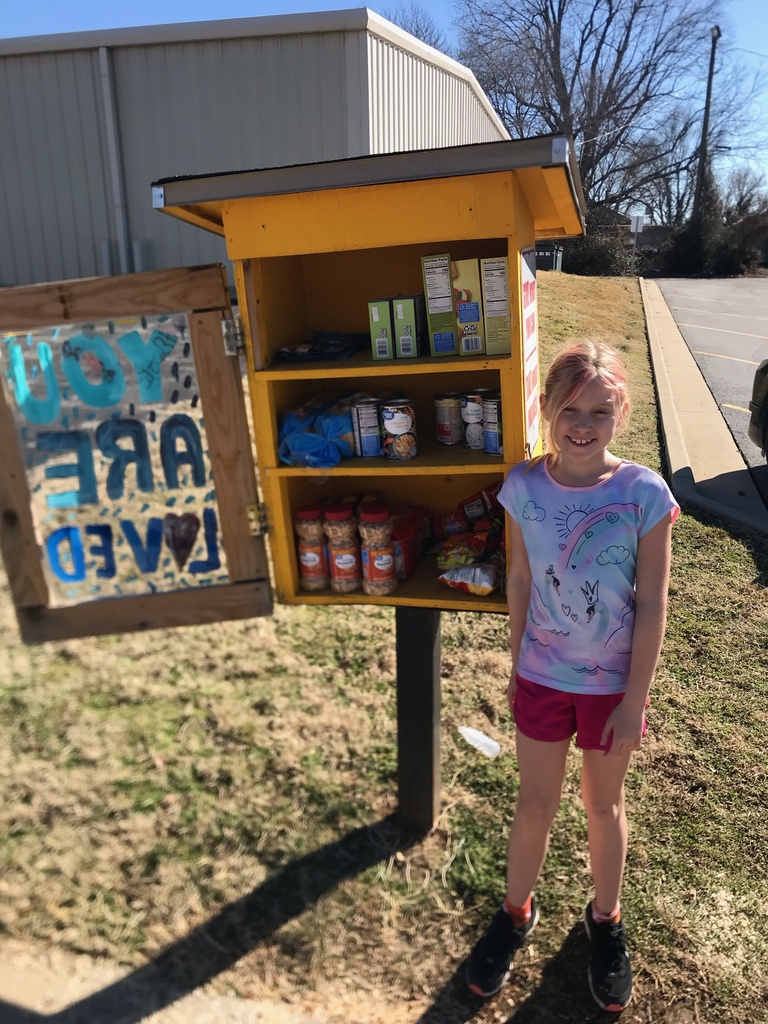 Female student stands in front of the Monett food pantry.