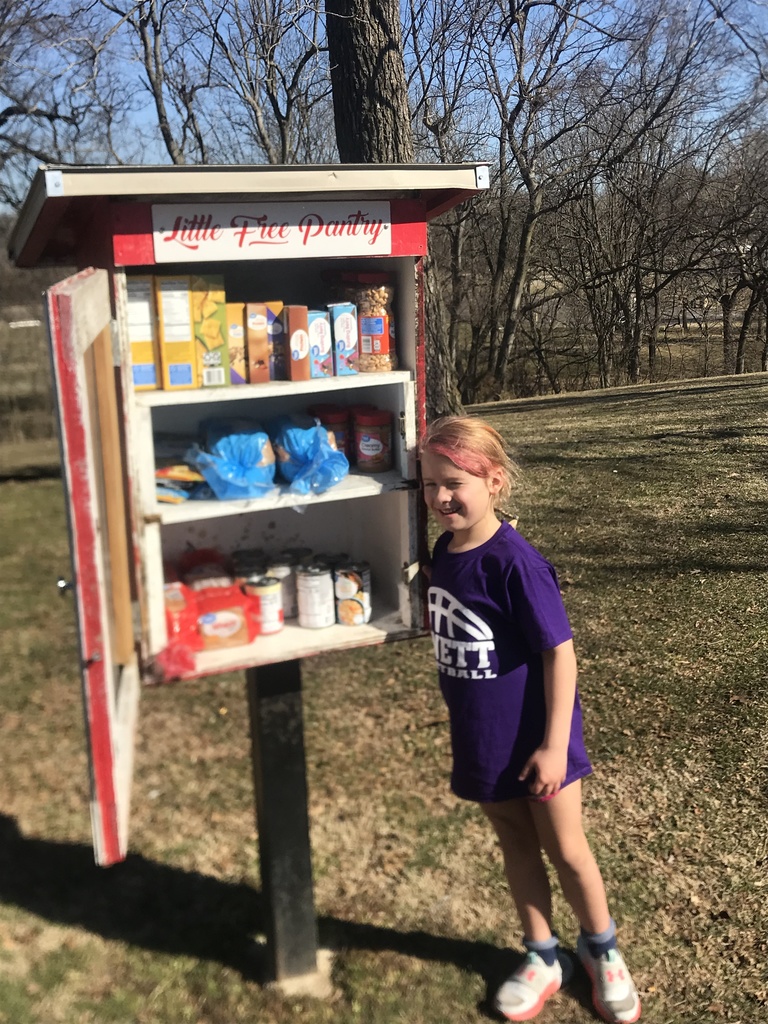 Female student stands in front of the Monett food pantry.