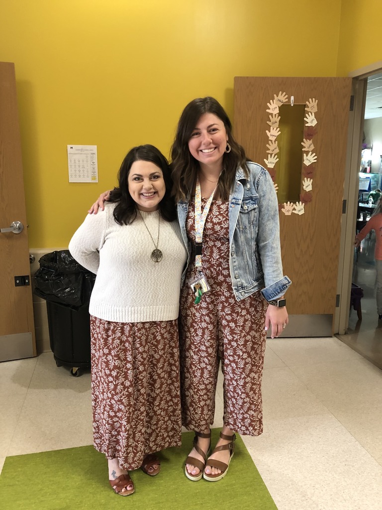 Two teachers wearing the same pattern of clothing took a minute to take a fun photo together. 