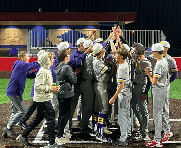 Group of boys in their baseball uniforms (gray color) hold the championship trophy and celebrate together.