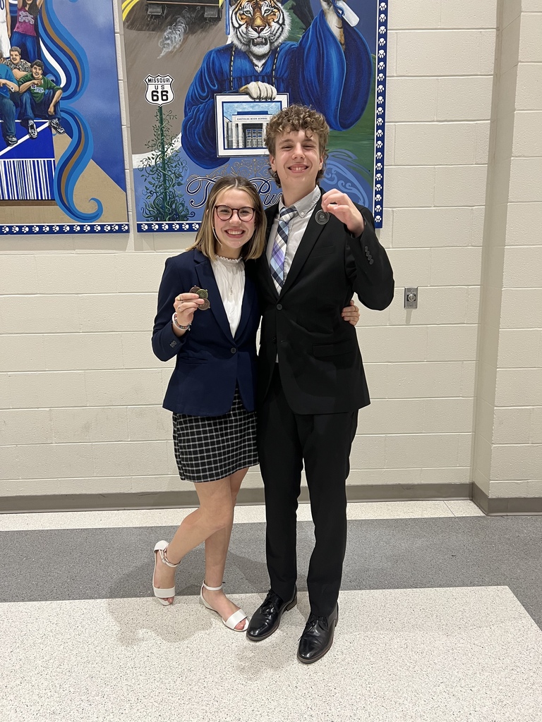 Two students holding their Speech and Debate Medal. 