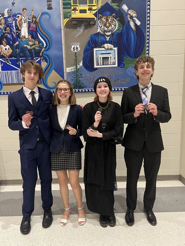 Four students holding their Speech and Debate medals 