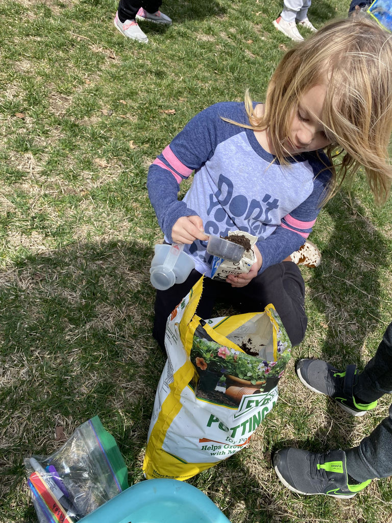 Student getting dirt for her classroom plant. 