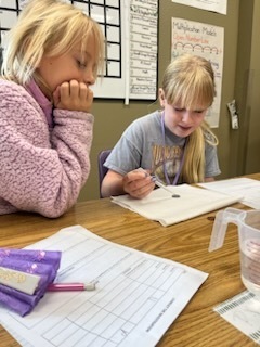 Students work on their science coin experiment. 