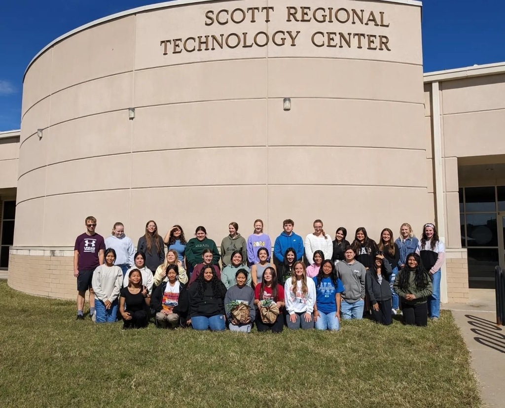 Group of students standing in front of the Scott Regional Technology Center campus and sign 